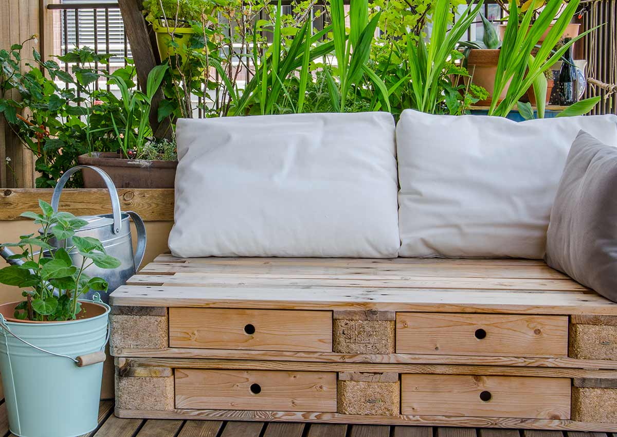 divanetto in pallet con cassetti sul balcone